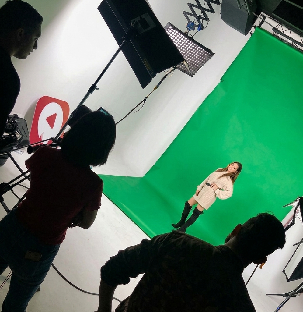Green-screen studio shoot in Morocco — talent on chroma-key cyclorama, AdKey Prod crew rigging key light and softboxes