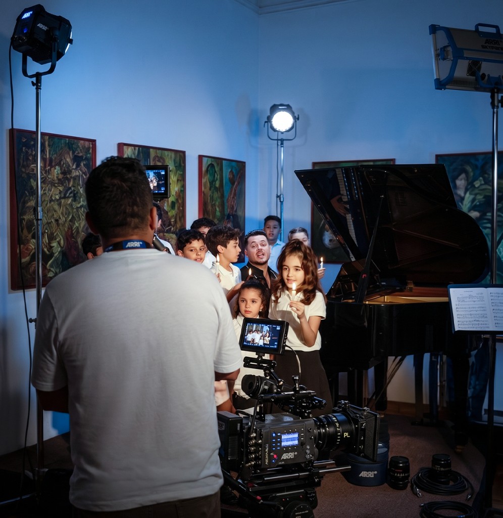 Music video maker in Morocco — children's choir performing around a grand piano under ARRI tungsten and Skypanel lighting, ARRI cinema camera in foreground