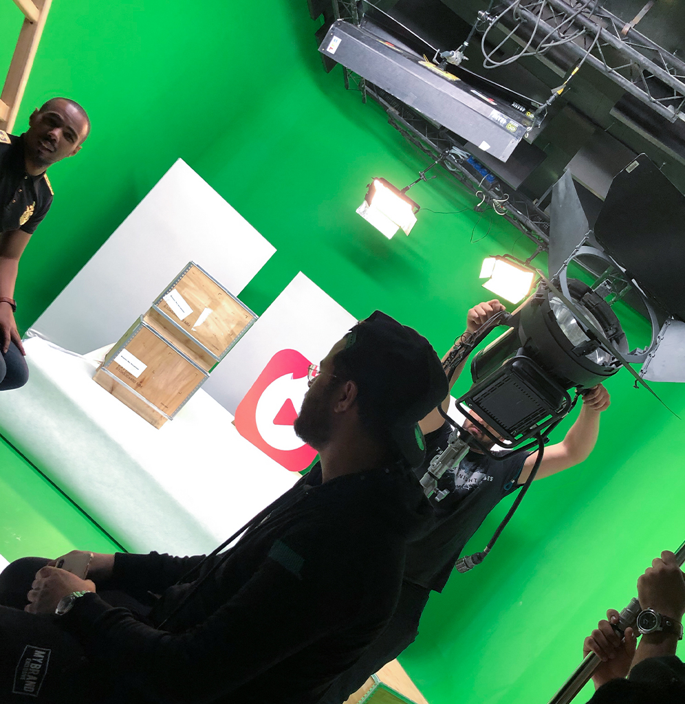 AdKey Prod green-screen studio in Morocco — set, chroma-key floor, broadcast lighting plot and gaffer rigging the key light