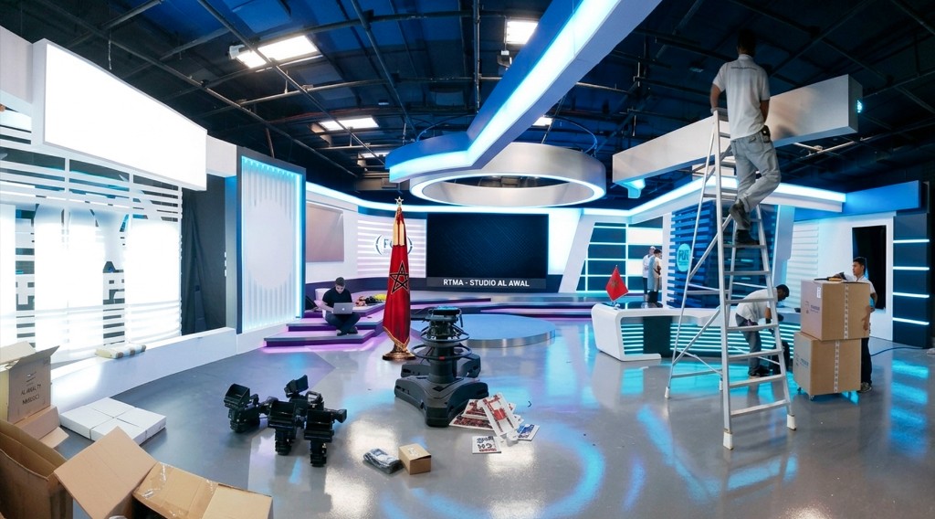 TV studio build and installation in Morocco — broadcast set under construction with floor cameras, LED rigging, anchor backdrop and the AdKey crew finishing the floor